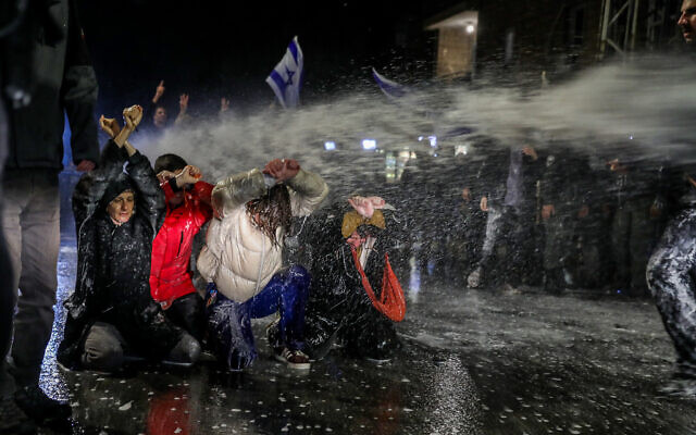 الشرطة تستخدم خراطيم المياه لتفريق المتظاهرين أمام منزل رئيس الوزراء بنيامين نتنياهو في القدس، 26 مارس 2023 (Noam Revkin Fenton / Flash90)