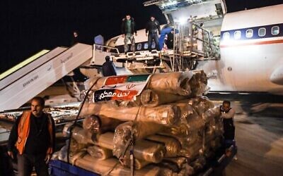 توضيحية: عمال يفرغون حمولة مساعدات من طائرة أرسلتها إيران، في مطار مدينة حلب شمال سوريا، فجر 8 فبراير 2023، بعد زلزال مدمر. (AFP)