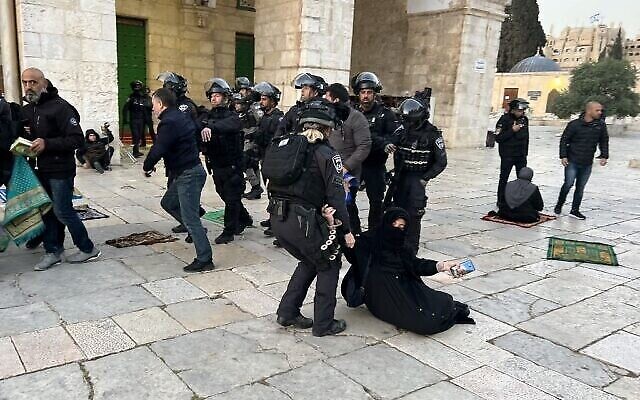 قوات الأمن الإسرائيلية تقوم بإخلاء مصلين مسلمين فلسطينيين يجلسون في ساحة المسجد الأقصى في القدس، 5 أبريل، 2023. (Ahmad Gharabli / AFP)