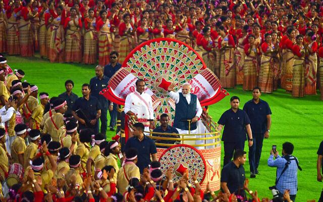 رئيس الوزراء الهندي ناريندرا مودي ورئيس وزراء ولاية آسام، هيمانتا بيسوا سارما، يصلان لمشاهدة عرض رقص بيهو في استاد ساروساجاي في جواهاتي، 14 أبريل، 2023. ( Biju BORO / AFP)
