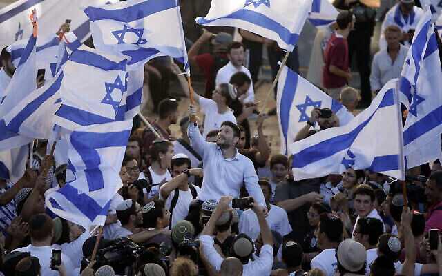 من الأرشيف:  عضو الكنيست بتسلئيل سموتريتش (وسط الصورة) يلوح بالعلم الإسرائيلي خلال مسيرة الأعلام السنوية بجوار باب. العامود، خارج البلدة القديمة في القدس، 15 يونيو، 2021. (AP Photo / Mahmoud Elean)