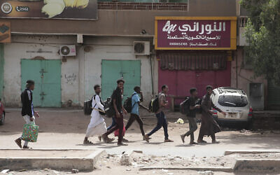 أشخاص يمشون أمام متاجر مغلقة في الخرطوم، السودان، 17 أبريل 2023 (AP Photo / Marwan Ali)