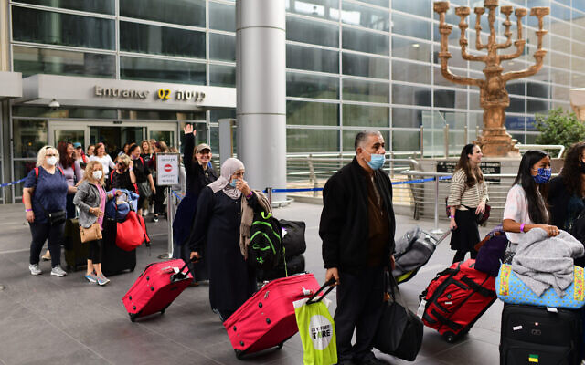 مسافرون في مطار بن غوريون الدولي، بعد أن فتحت إسرائيل حدودها وسمحت للسائحين بدخول البلاد، بعد أشهر من إغلاقها بسبب وباء كوفيد-19، 1 نوفمبر 2021 (Tomer Neuberg / FLASH90)