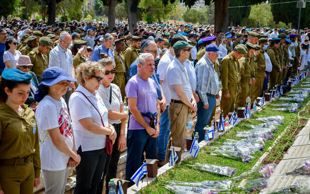 اشخاص يقفون دقيقة صمت اثناء انطلاق صافرة الانذار في يوم الذكرى الةطني في مقبرة نحلات يتسحاق العسكرية في تل ابيب، 4 مايو 2022 (Avshalom Sassoni / Flash90)