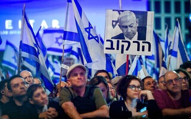 آلاف الإسرائيليين يتظاهرون ضد الإصلاح القضائي الذي تقترحه الحكومة، في تل أبيب، في 22 أبريل 2023، على اللافتة التي تحمل صورة رئيس الوزراء بنيامين نتنياهو  كُتب  "الفاسد". (Avshalom Sassoni/Flash90)