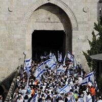 مشاركون يهود  في "مسيرة الأعلام" يمرون عبر باب العامود إلى البلدة القديمة في القدس، 29 مايو، 2022، حيث تحتفل إسرائيل ب"يوم القدس". (Ahmad Gharabli/AFP)