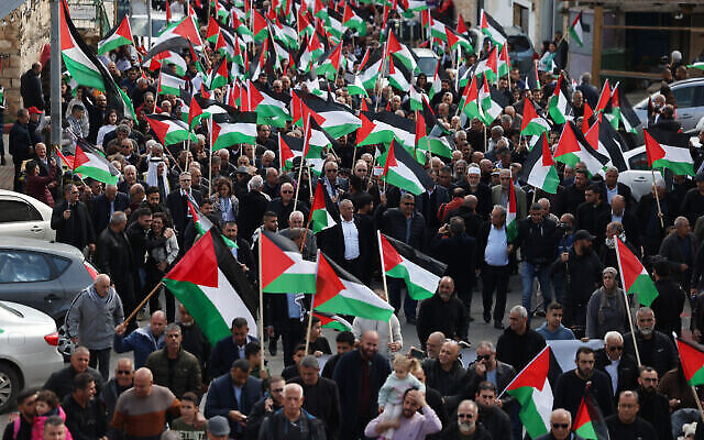 توضيحية: متظاهرون يلوحون بالأعلام الفلسطينية خلال مظاهرة بمناسبة إحياء ذكرى "يوم الأرض" في مدينة سخنين شمال إسرائيل، 30 مارس، 2023. (AHMAD GHARABLI / AFP)