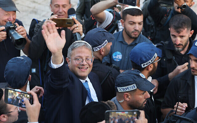 وزير الأمن القومي إيتمار بن غفير، محاطا برجال الشرطة، يحيي الناس المتجمعين أمام باب العامود المؤدي إلى البلدة القديمة في القدس، 18 مايو، 2023. (AHMAD GHARABLI / AFP)