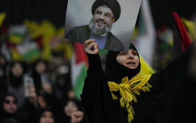 سيدة تردد هتافات وهي تحمل صورة زعيم حزب الله السيد حسن نصر الله خلال تجمع حاشد بمناسبة يوم القدس في ضاحية بيروت الجنوبية، لبنان، 14 أبريل 2023 (AP Photo / Hussein Malla)