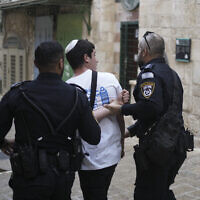 توضيحية: شرطيان يعتقلان شابا اسرائيليا بعد ان رددت مجموعته شعارات عند مدخل المسجد الاقصى خلال مسيرة الأعلام السنوية في البلدة القديمة بالقدس، 18 مايو، 2023. (AP Photo / Maya Alleruzzo)