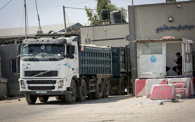 شاحنات فلسطينية محملة بالركام والحديد والاسمنت تدخل عبر معبر كيرم شالوم التجاري جنوب قطاع غزة، 1 سبتمبر، 2021. (Abed Rahim Khatib / Flash90)