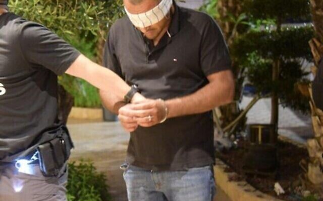 مشتبه به اعتُقل في مداهمة استهدفت مشتبه بهم بإجبار المحلات التجارية على دفع الخاوة في شمال اسرائيل، 22 مايو، 2023. (Israel Police)