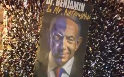 لافتة كبيرة تحمل صورة لرئيس الوزراء الإسرائيلي بنيامين نتنياهو تصوره على أنه الدكتور جيكل والسيد هايد، تل أبيب، 27 مايو، 2023. (لقطة فيديو)