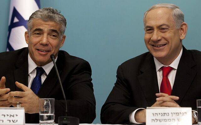 ملف: رئيس الوزراء بنيامين نتنياهو (يمين) ووزير المالية آنذاك يائير لبيد خلال مؤتمر صحفي حول إصلاح رئيسي للموانئ الإسرائيلية، في القدس، 3 يوليو 2013 (Flash90)