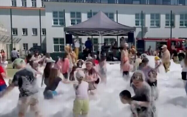 الأطفال بحفلة فقاعات صابون في كازيميرز دولني، بولندا، بمناسبة يوم الطفل، 1 يونيو، 2023. (Screenshot from YouTube/Kan via JTA)