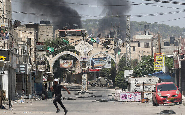 فلسطينيون يركضون وسط اشتباكات خلال عملية عسكرية إسرائيلية في جنين بالضفة الغربية، 3 يوليو، 2023. (Jaafar ASHTIYEH / AFP)