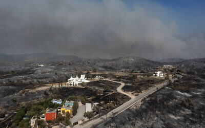 صورة جوية تظهر دخان يتصاعد خلف قرية كيوتاري بجزيرة رودوس اليونانية، 24 يوليو 2023 (Spyros BAKALIS / AFP)