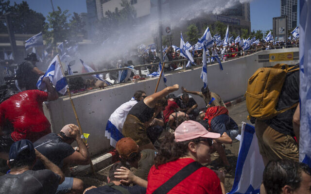 الشرطة الإسرائيلية تستخدم خراطيم المياه لتفريق متظاهرين أغلقوا طريقًا خلال احتجاج على خطط حكومة رئيس الوزراء بنيامين نتنياهو لإصلاح النظام القضائي، في تل أبيب، 11 يوليو 2023 (AP Photo / Oded Balilty)