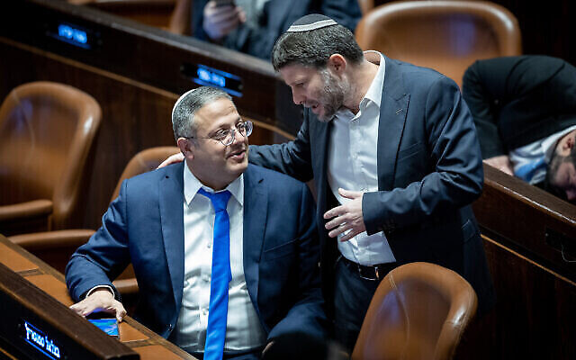 زعيم "عوتسما يهوديت" إيتمار بن غفير (على يسار الصورة) يتحدث إلى زعيم حزب "الصهيونية الدينية" بتسلئيل سموتريتش في الكنيست، 29 ديسمبر، 2022. (Yonatan Sindel / FLASH90)