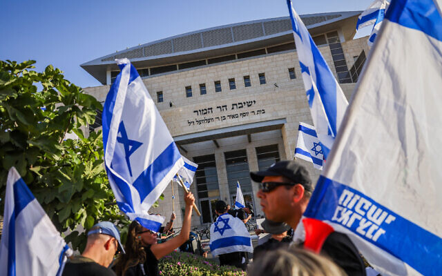 ناشطون يتظاهرون ضد الإصلاح القضائي المخطط للحكومة، خارج مدرسة "هار همور" الدينية في هار حوما، القدس الشرقية، 5 يوليو 2023 (Chaim Goldberg / Flash90)