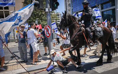 حصان يدوس على رجل في مظاهرة ضد الإصلاح القضائي في تل أبيب، 11 يوليو 2023 (Chaim Goldberg / Flash90)