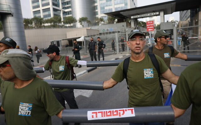 متظاهرون ضد الإصلاح القضائي يغلقون مدخل وزارة الدفاع في تل أبيب، 18 يوليو 2023 (Chaim Goldberg / Flash90)