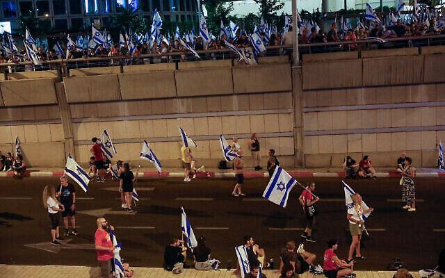 نشطاء مناهضون للإصلاح يتظاهرون ضد خطة الحكومة لإصلاح القضائي، على طريق أيالون السريع في تل أبيب، 29 يوليو، 2023. (Miriam Alster / Flash90)
