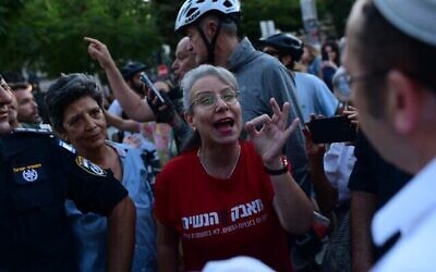 امرأة تتجادل مع نشطاء من منظمة "روش يهودي" خلال صلاة جماعية في الشارع بمناسبة يوم الغفران في ميدان ديزنغوف في تل أبيب، 24 سبتمبر، 2023. (Tomer Neuberg/Flash 90)