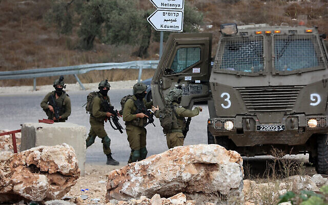 جنود إسرائيليون يقومون بدورية بالقرب من مدينة طولكرم بالضفة الغربية بعد اشتباكات بين مسلحين فلسطينيين والقوات الإسرائيلية في 5 أكتوبر، 2023. (Zain JAAFAR / AFP)