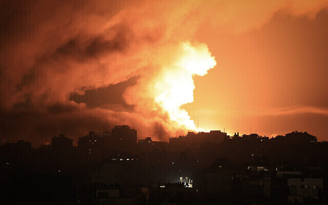 حريق ودخان يتصاعدان فوق المباني في مدينة غزة خلال غارة جوية إسرائيلية، 13 أكتوبر، 2023. (Mahmud Hams / AFP)