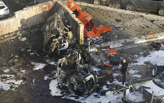 رجال إطفاء إسرائيليون يخمدون حريقا بعد أن أصاب صاروخ أطلق من قطاع غزة ساحة انتظار للسيارات في أشكلون، 7 أكتوبر 2018. 2023.(AP Photo/Tsafrir Abayov)