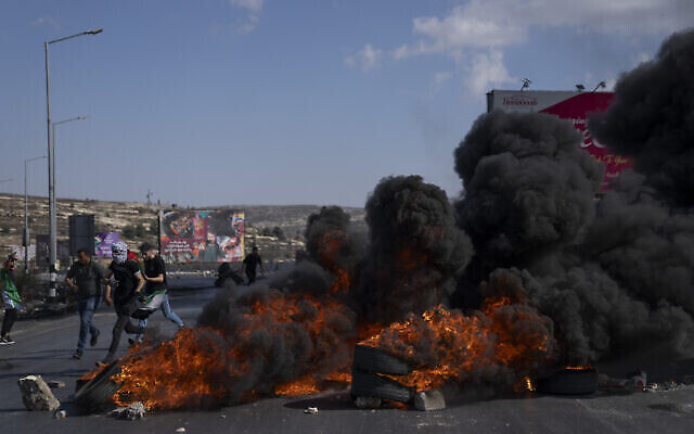 فلسطينيون يشتبكون مع القوات الإسرائيلية في أعقاب مظاهرة دعما لقطاع غزة، في مدينة رام الله بالضفة الغربية، 13 أكتوبر، 2023، وسط قتال بين حماس وإسرائيل بعد أن شنت الحركة التي تحكم غزة هجوما مدمرا على إسرائيل.(AP Photo/Nasser Nasser)