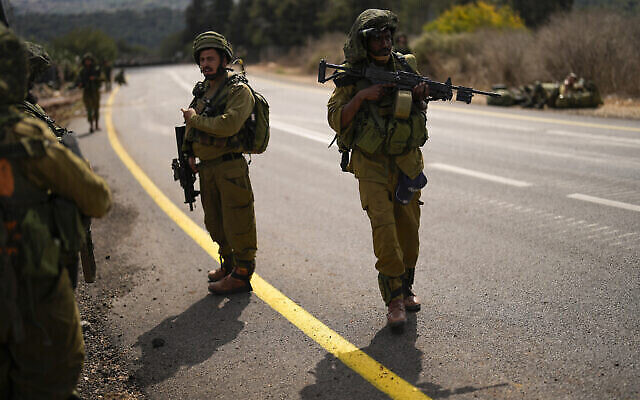 جنود إسرائيليون يقومون بدورية على طول طريق بالقرب من الحدود بين إسرائيل ولبنان، في إسرائيل، 16 أكتوبر، 2023. (AP Photo/Francisco Seco)