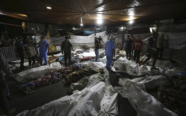 جثث فلسطينيين قتلوا في انفجار في المستشفى الأهلي العربي، في الساحة الأمامية لمستشفى الشفاء في مدينة غزة، وسط قطاع غزة، 17 أكتوبر، 2023. (AP/Abed Khaled)