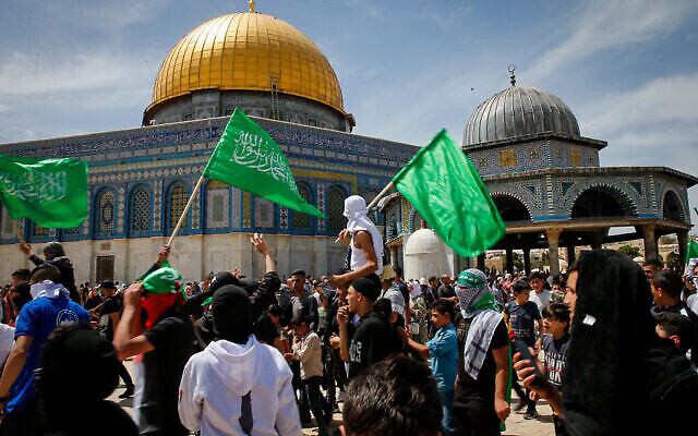متظاهرون يلوحون بأعلام حركة حماس بعد صلاة الجمعة في شهر رمضان، في المسجد الأقصى بالبلدة القديمة بالقدس، 22 أبريل، 2022. (Jamal Awad/Flash90)