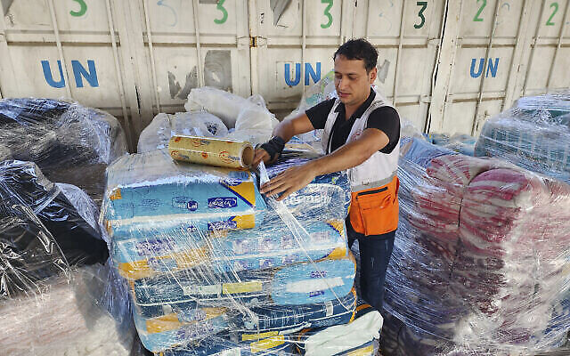 من الأرشيف: عمال الأمم المتحدة والهلال الأحمر يقومون بإعداد المساعدات للتوزيع على الفلسطينيين في مستودع الأونروا في دير البلح، قطاع غزة، 23 أكتوبر، 2023. (AP Photo/Hassan Eslaiah)