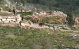 مستوطنون ملثمون يلقون الحجارة على منازل فلسطينية في قرية بورين شمال الضفة الغربية، 3 مارس، 2023. (Yesh Din)