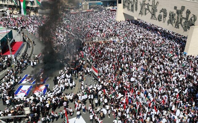 متظاهرون يحرقون الأعلام الإسرائيلية خلال مظاهرة في ساحة التحرير ببغداد في 13 أكتوبر، 2023، وسط المعارك المستمرة بين إسرائيل وحركة حماس الإسلامية الفلسطينية. (Ahmad Al-Rubaye / AFP)