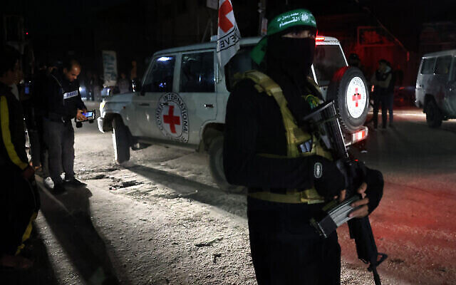 توضيحية:  مسلح من حماس يقوم بالحراسة بينما تقوم مركبة تابعة للصليب الأحمر بنقل رهائن تم إطلاق سراحهم حديثا في رفح، في جنوب قطاع غزة، في 28 نوفمبر، 2023. (AFP)