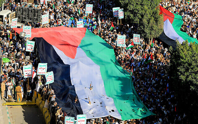يمنيون يلوحون بالأعلام ويرددون شعارات خلال مسيرة مؤيدة للفلسطينيين في العاصمة صنعاء التي يسيطر عليها الحوثيون، 8 ديسمبر، 2023. (MOHAMMED HUWAIS / AFP)