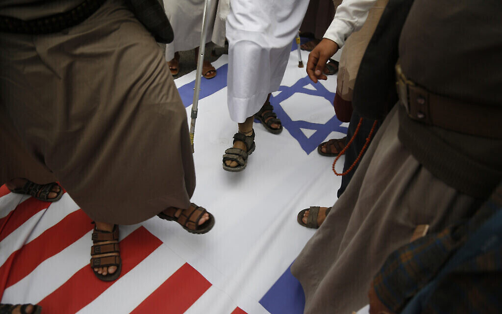 أنصار الحوثيين يدوسون على العلمين الأمريكي والإسرائيلي، 26 مارس 2023، في صنعاء، اليمن. (AP Photo/Hani Mohammed)