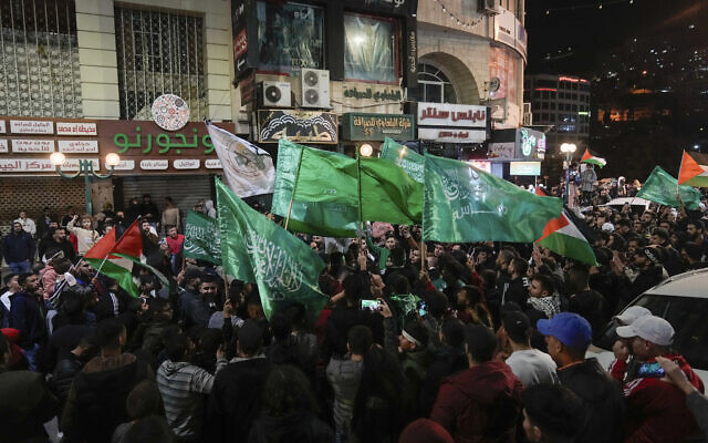 فلسطينيون يلوحون بأعلام حماس في مدينة نابلس بالضفة الغربية أثناء احتفالهم بالإفراج عن أسرى أمنيين فلسطينيين، 24 نوفمبر، 2023. (AP Photo/ Majdi Mohammed)