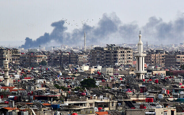 توضيحية: الدخان يتصاعد فوق المباني بعد غارة إسرائيلية على مشارف دمشق، 22 نوفمبر، 2023. (AFP)