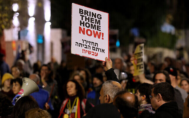 متظاهرون يرفعون لافتات خلال مسيرة للمطالبة بالإفراج عن الرهائن الذين تحتجزهم حركة حماس، بالقرب من مقر إقامة رئيس الوزراء في القدس، 22 يناير، 2024. (Ahmad Gharabli/AFP)