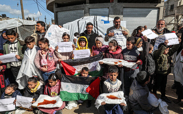 رجال وأطفال فلسطينيون يتجمعون في مظاهرة في رفح بجنوب قطاع غزة في 30 يناير 2024، للمطالبة بمواصلة الدعم الدولي لوكالة الأمم المتحدة لإغاثة وتشغيل اللاجئين الفلسطينيين (الأونروا). (AFP)
