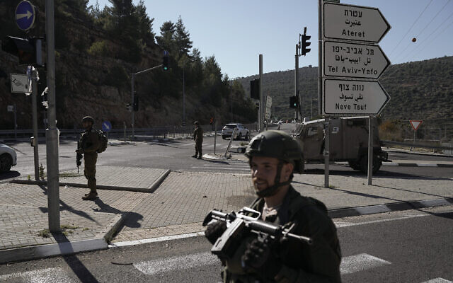 جنود إسرائيليون يقفون بالقرب من موقع هجوم إطلاق نار فلسطيني، بالقرب من وادي عيون الحرامية في الضفة الغربية، 7 يناير، 2024. (AP Photo/Leo Correa)