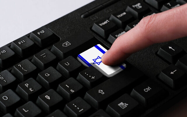 شخص يستخدم لوحة مفاتيح تحمل العلم الإسرائيلي (Hakan Gider/ iStock)