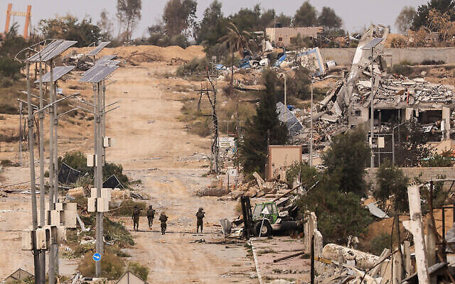 جنود إسرائيليون يقومون بدورية في حي الزيتون بمدينة غزة في 25 نوفمبر، 2023، في اليوم الثاني من الهدنة بين إسرائيل وحماس. (Mahmud Hams/AFP)