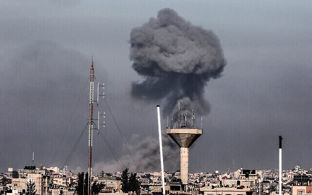 تظهر هذه الصورة الملتقطة من رفح في جنوب قطاع غزة، الدخان يتصاعد فوق المباني في خان يونس خلال القصف الإسرائيلي في 8 فبراير، 2024، مع استمرار القتال بين إسرائيل وحركة حماس الفلسطينية.(Mahmud Hams/AFP)