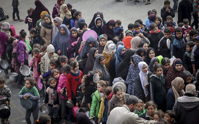 نازحون فلسطينيون يتجمعون للحصول على الطعام في مدرسة حكومية في رفح بجنوب قطاع غزة، 19 فبراير، 2024. (Mohammed Abed/AFP)